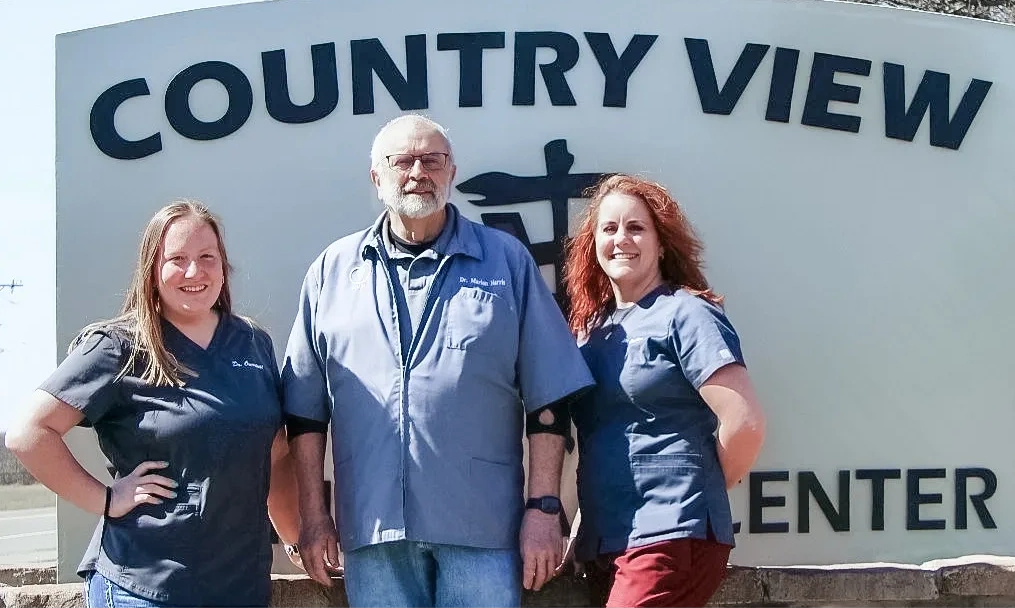 Country View Animal Care Center crew at the ranch sign